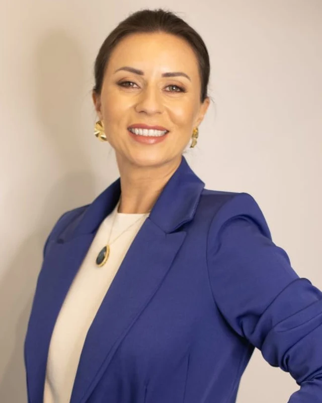 Tatiane de Almeida, fisioterapeuta, sorrindo, de blazer azul